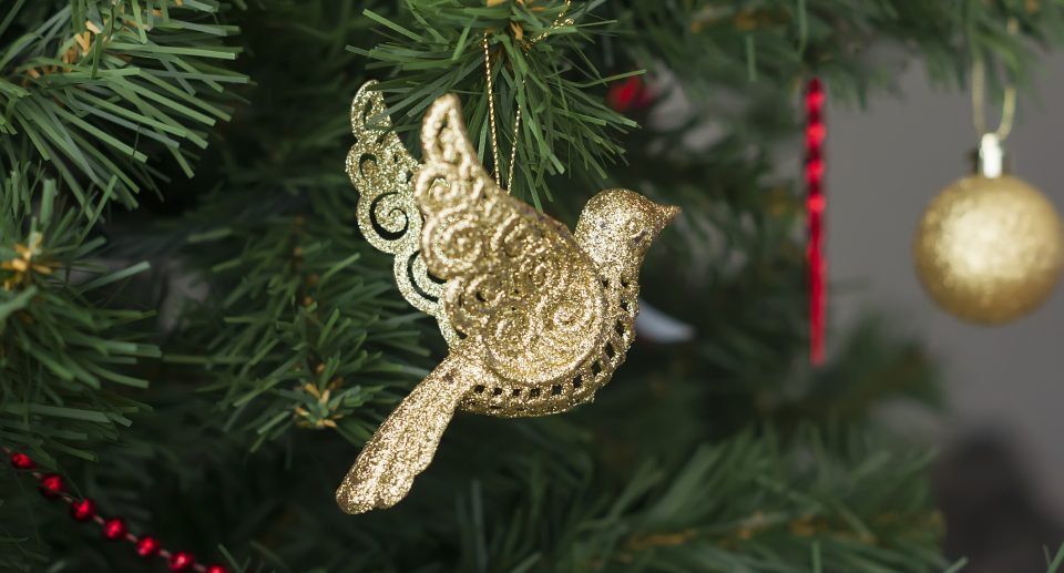 Das Foto zeigt Christbaumschmuck in Form eines goldenen Vogels.